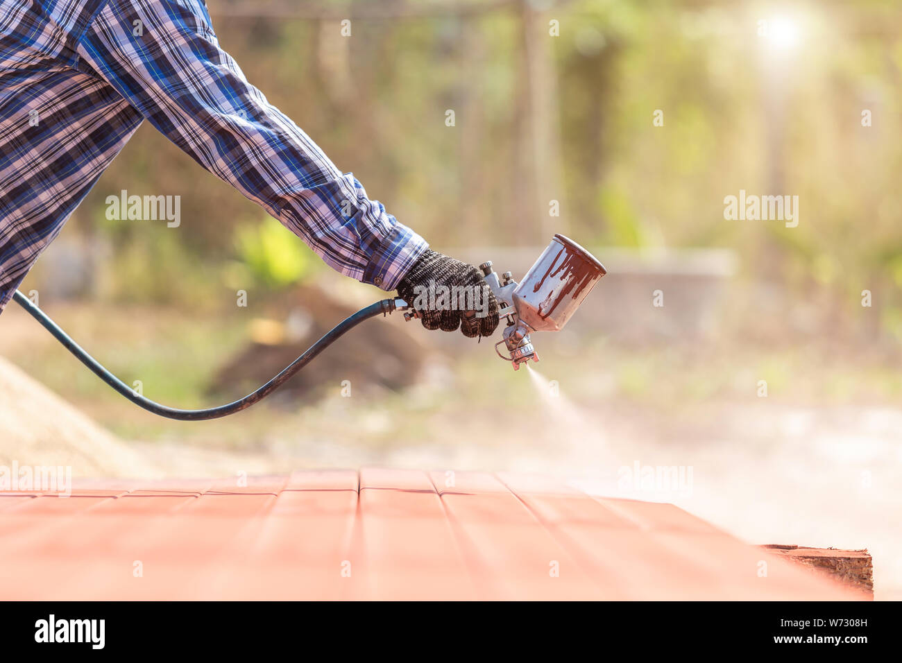 Construction worker spraying paint to steel pipe to prevent the rust on the surface Stock Photo