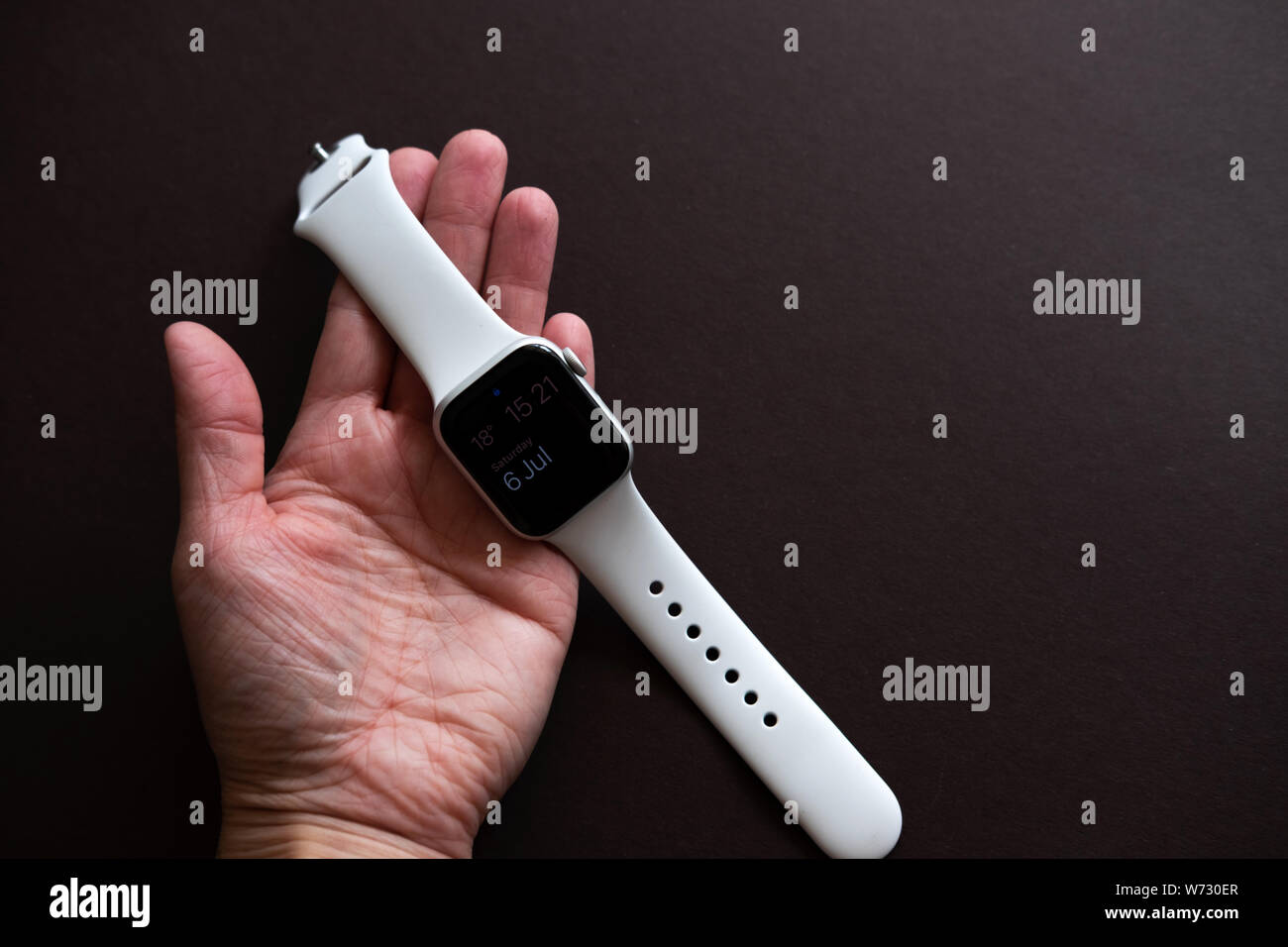 Chekhov, Russia - July 19, 2019: Apple Watch Series 4 white color with hand. A new watch from an Apple company closeup isolated on dark background Stock Photo