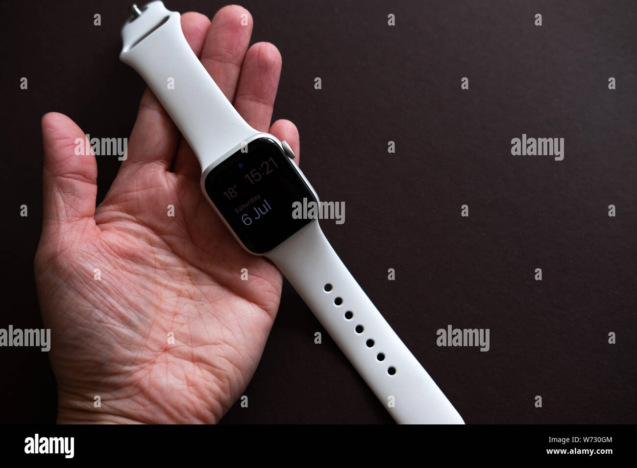 Chekhov, Russia - July 19, 2019: Apple Watch Series 4 white color with hand. A new watch from an Apple company closeup isolated on dark background Stock Photo