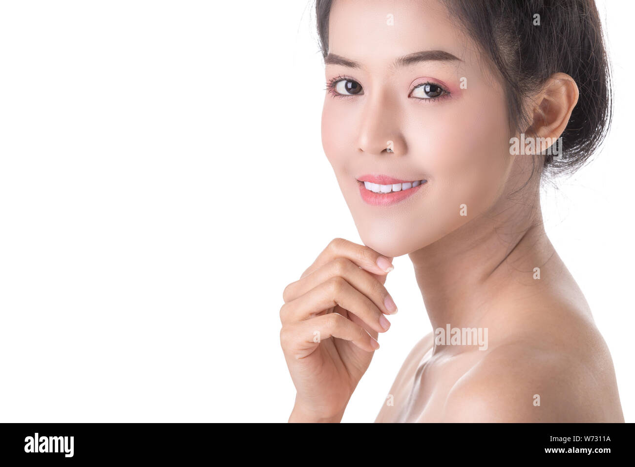 Beautiful Young Asian Woman with Cosmetic on own face. Cosmetologist, Skin care or Beauty concept. Studio shot and isolated on White background Stock Photo