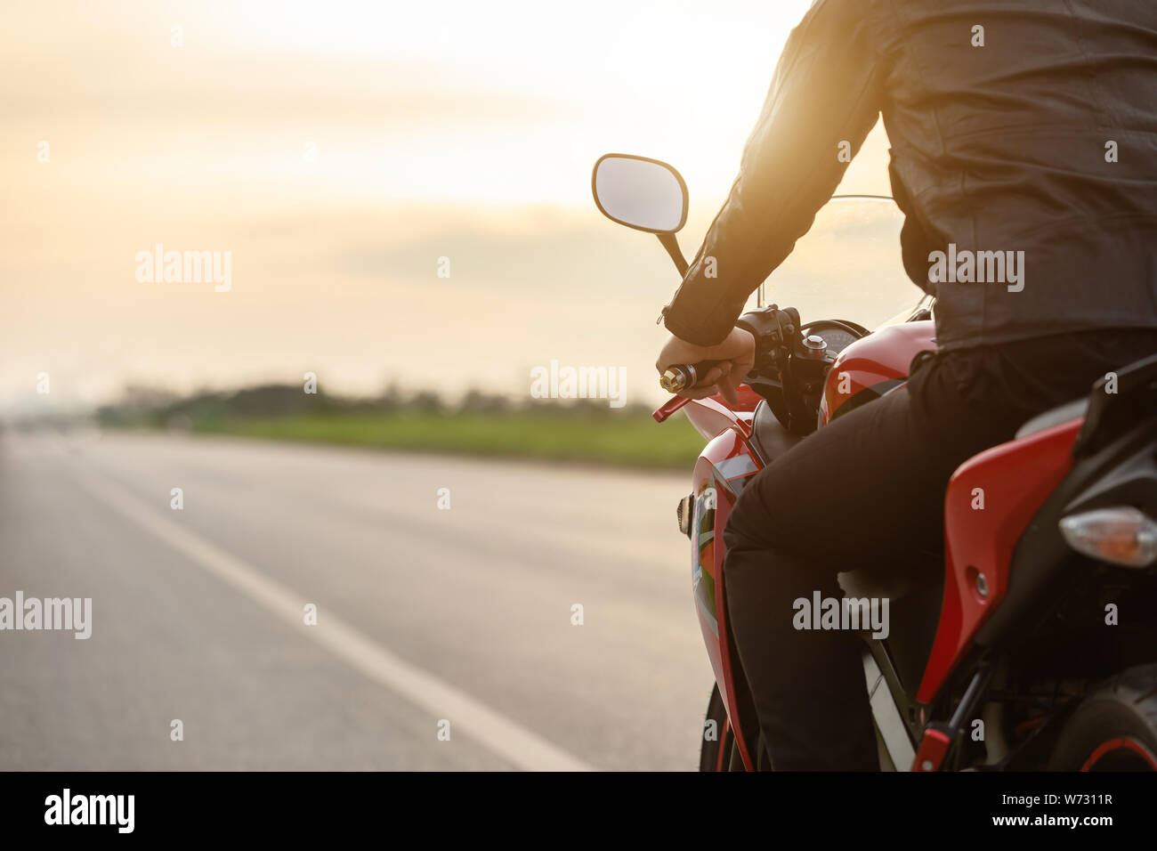 Handsome motorcyclist wear leather jacket and sitting motorbike at the