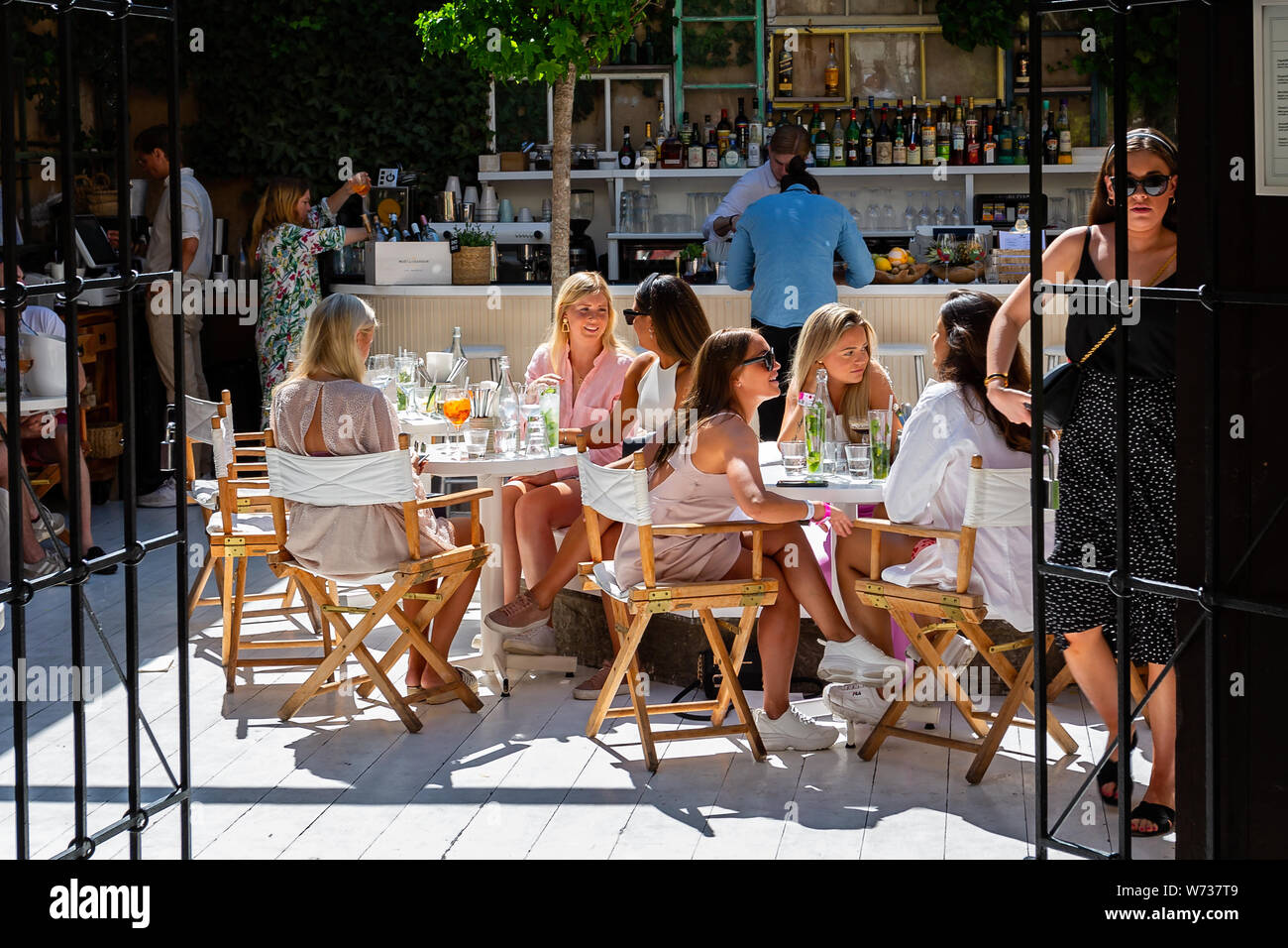 Group of beautiful young women sat at tables chatting and drinking cocktails in Visby, Gotland, Sweden on 20 July 2019 Stock Photo