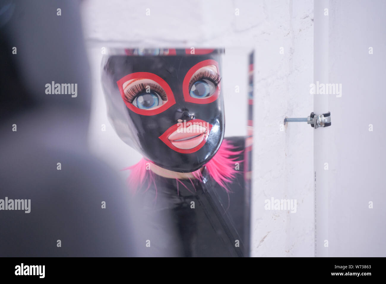 portrait of a beauty girl with big plastic anime head in latex mask Stock Photo