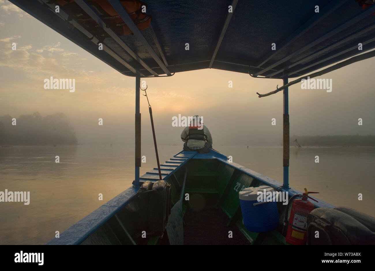 Navigating the Tambopata River in the fog, Tambopata National Reserve, Peruvian Amazon Stock Photo