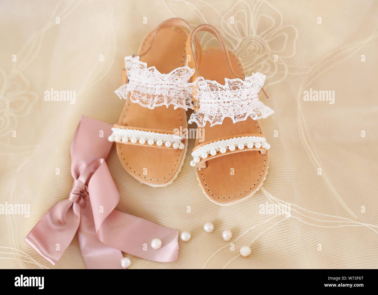 baptism baby shoes with white lace and pearls - greek leather sandals -  christening shoes Stock Photo - Alamy