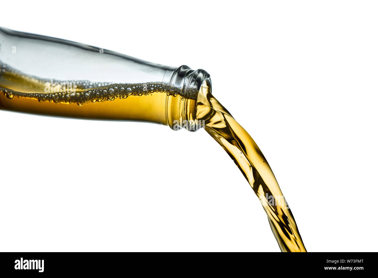 Golden lager pouring from clear beer bottle. Stop action closeup on white background. Stock Photo