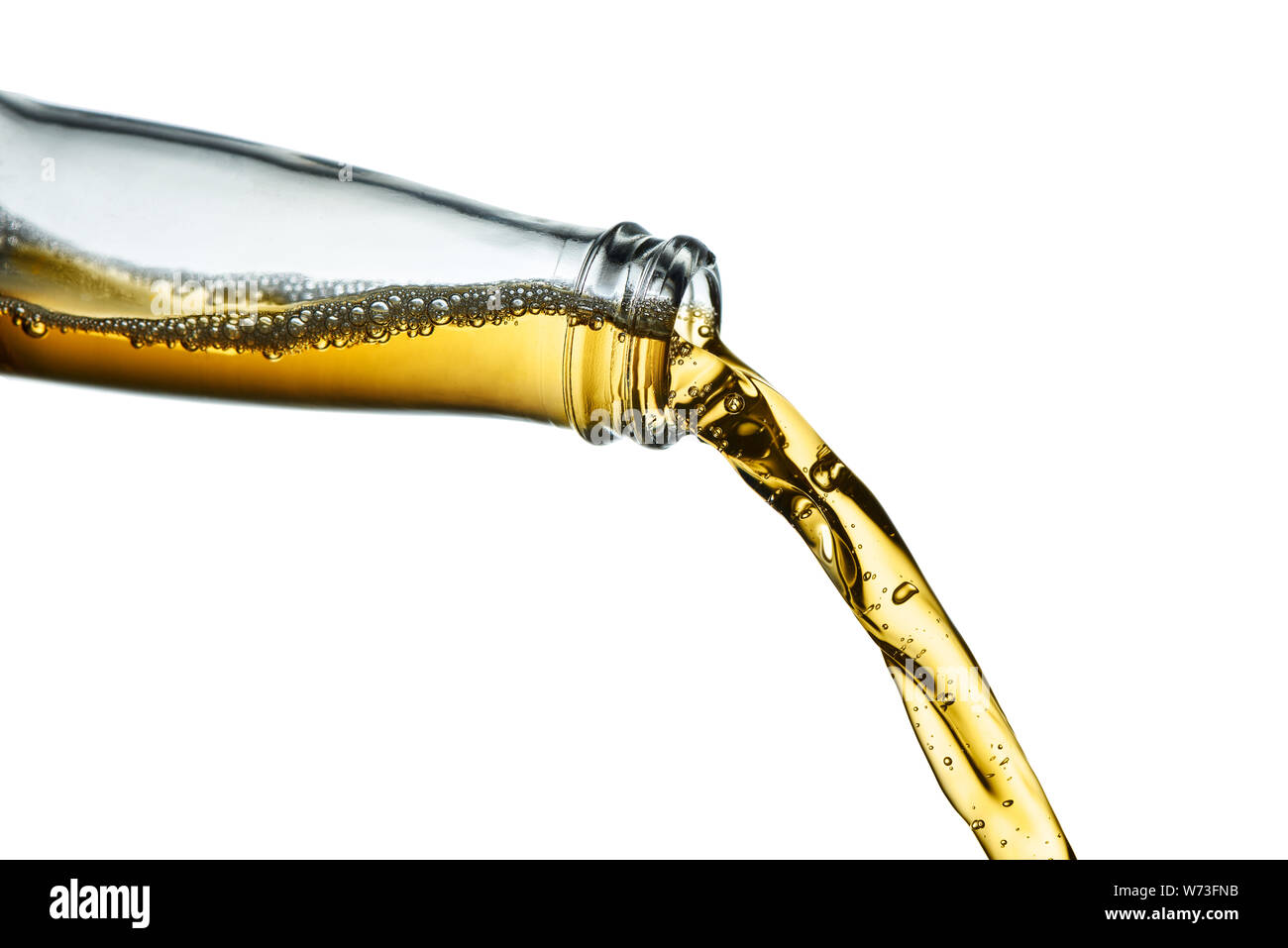 Stop action closeup of golden amber beer pouring from clear bottle on white  background Stock Photo
