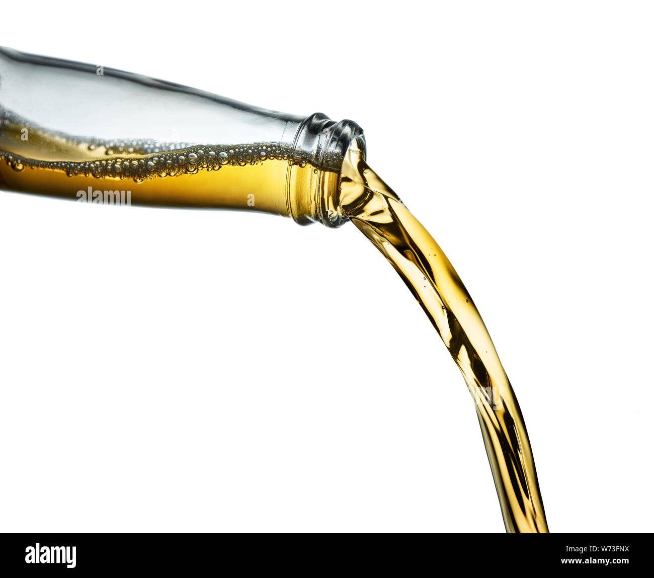 Stop action closeup of amber beer pouring from clear bottle on white background Stock Photo