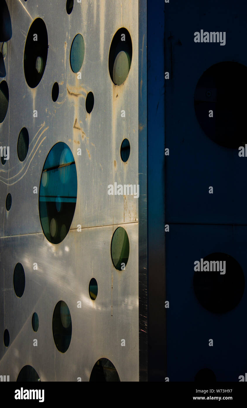 A series of glass windows openings on a steel surface with varied sizes represent different opinions, variations, on hard truth. Stock Photo