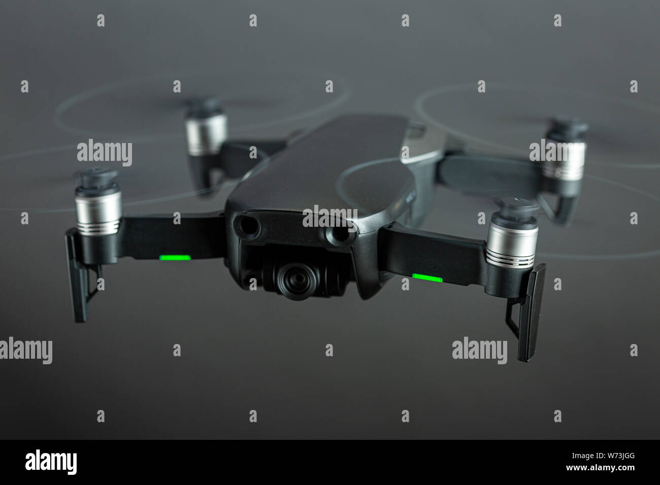 Drone in flight with spinning propellers and green positioning lights