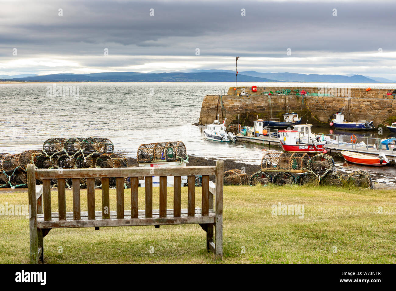 wooden bench in front of the port of Portmahomack in Scotland Stock Photo