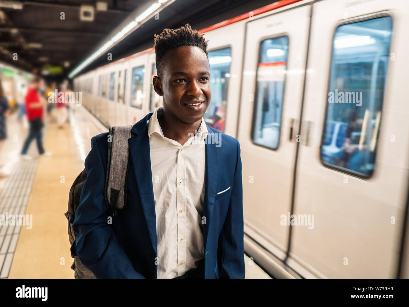African American businessman wearing blue suit and backpack Stock Photo
