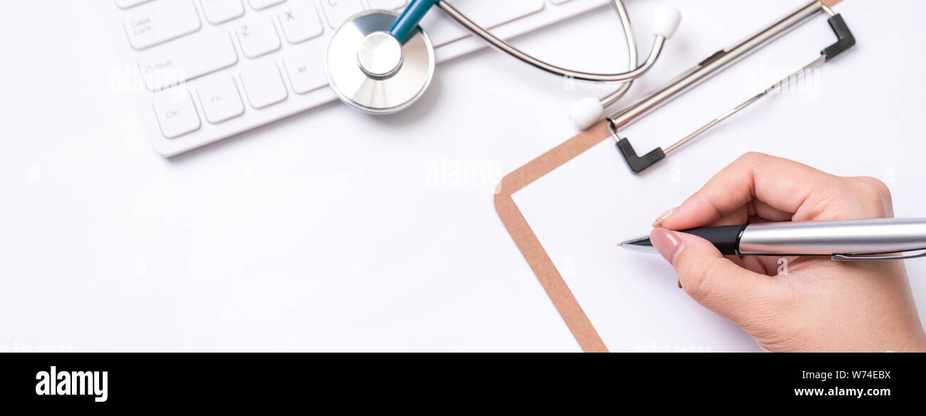 Female doctor writing a medical record case over clipboard on white ...