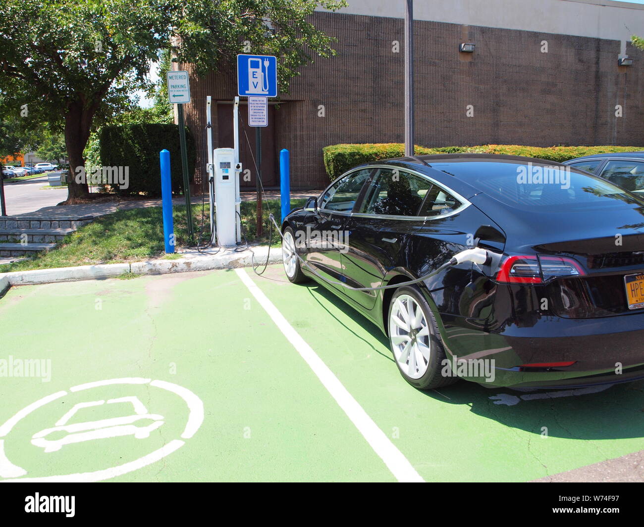 Newly installed electric vehicle charging station in a public parking lot in Nyack, New York not far from the Hudson River in Rockland County. Stock Photo