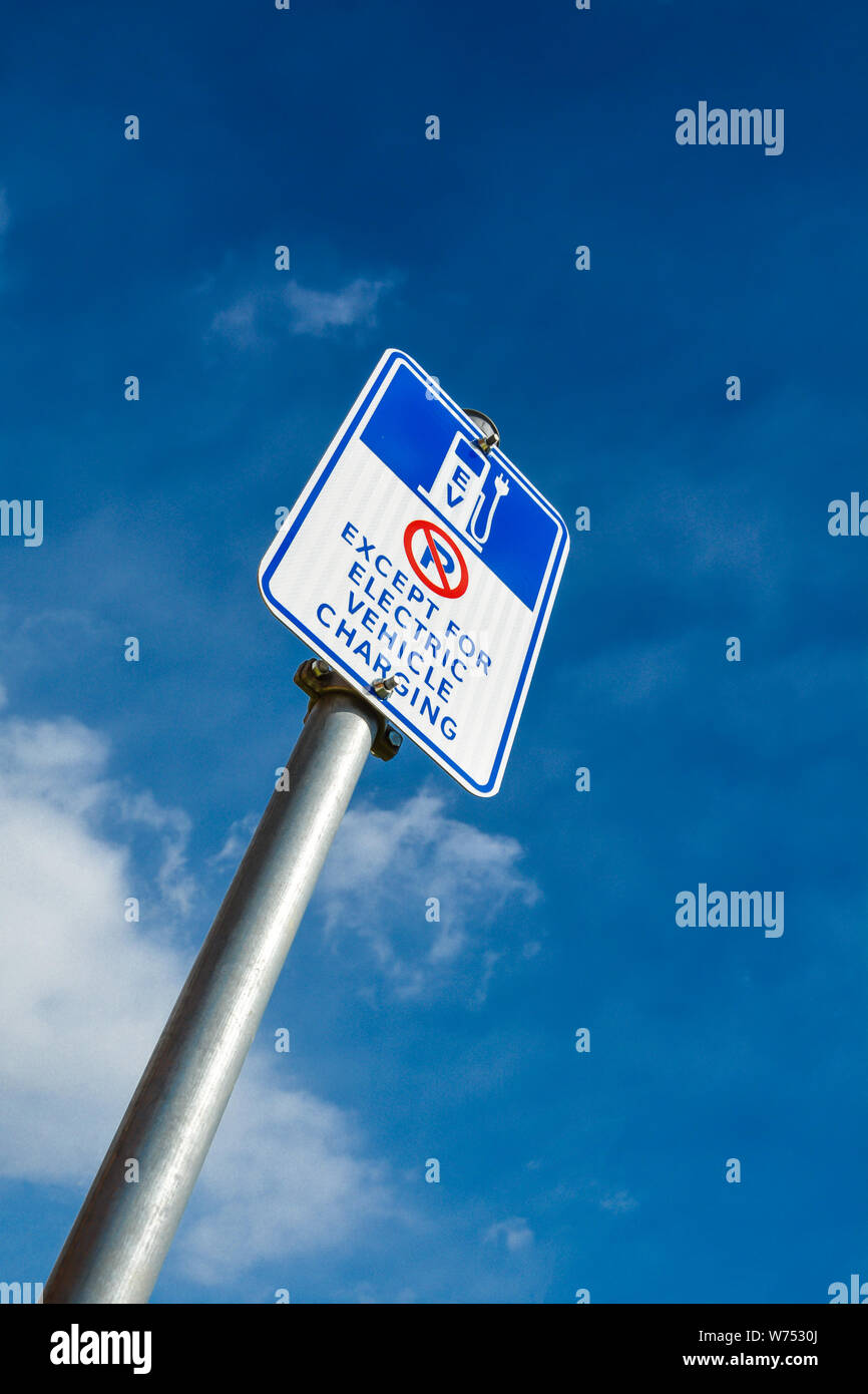 EV - electric vehicle charging station sign on blue sky background Stock Photo