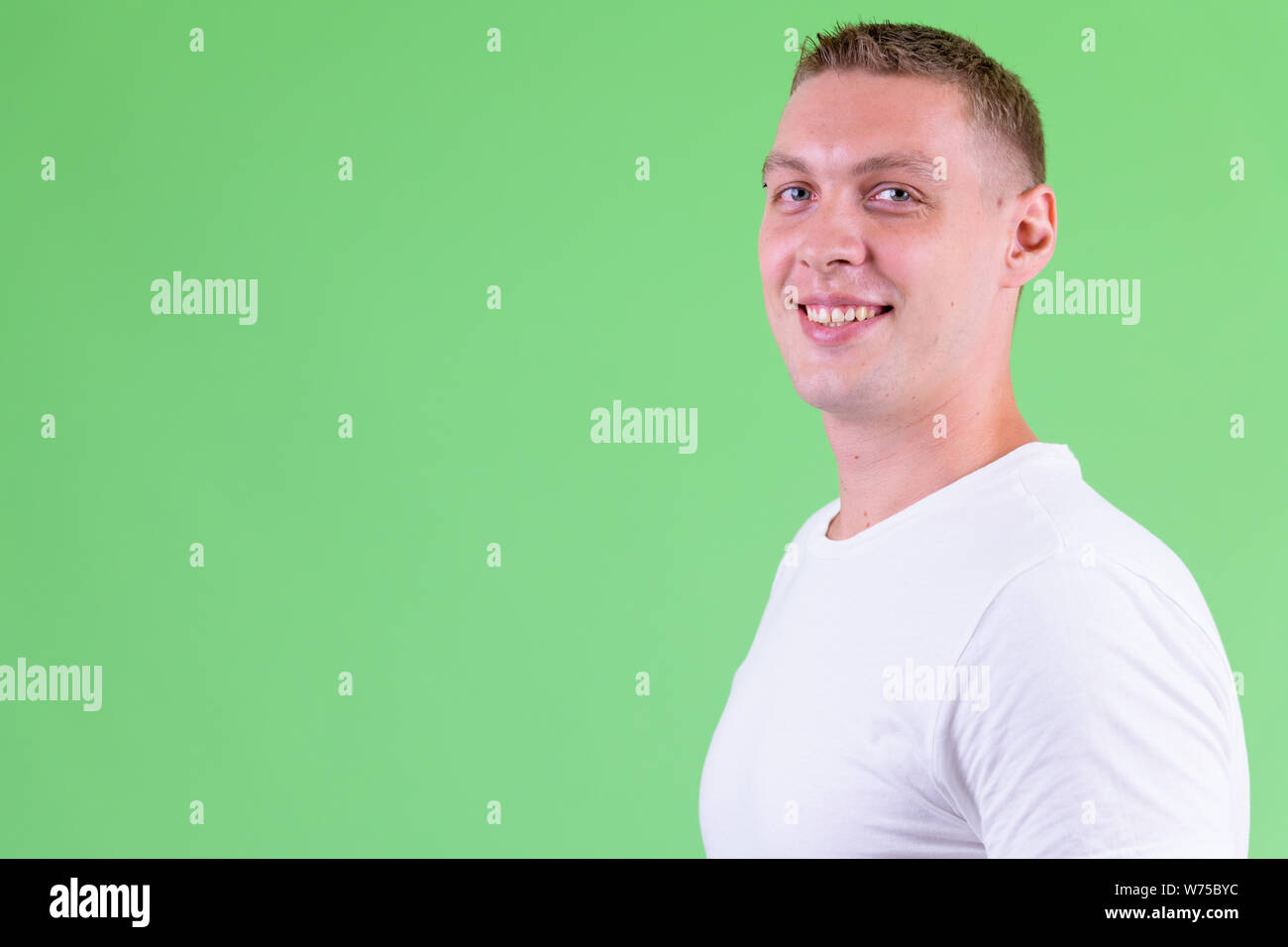 Closeup profile view of happy young man looking at camera Stock Photo ...
