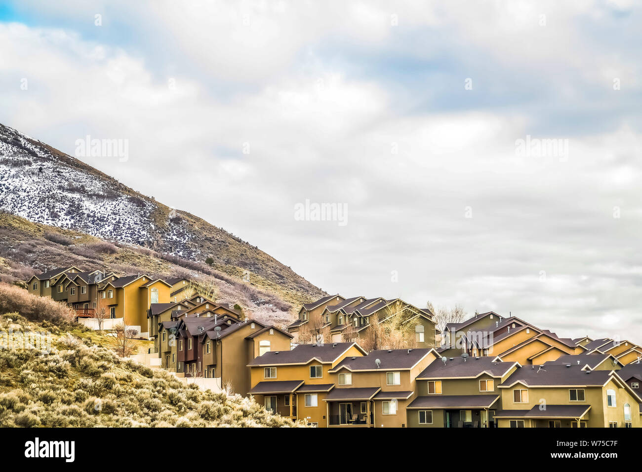 Row of houses built on the slope of a mountain with cloudy blue sky  background Stock Photo - Alamy, image size:1300x957