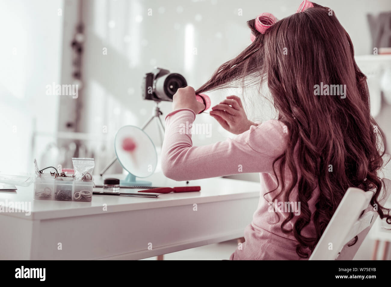 Nice cute pleasant girl wearing hair rollers Stock Photo - Alamy