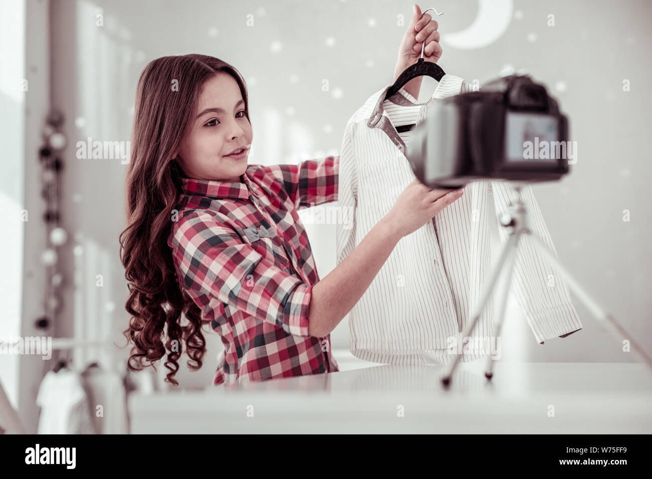 Pleasant cute girl showing her stripped shirt Stock Photo - Alamy