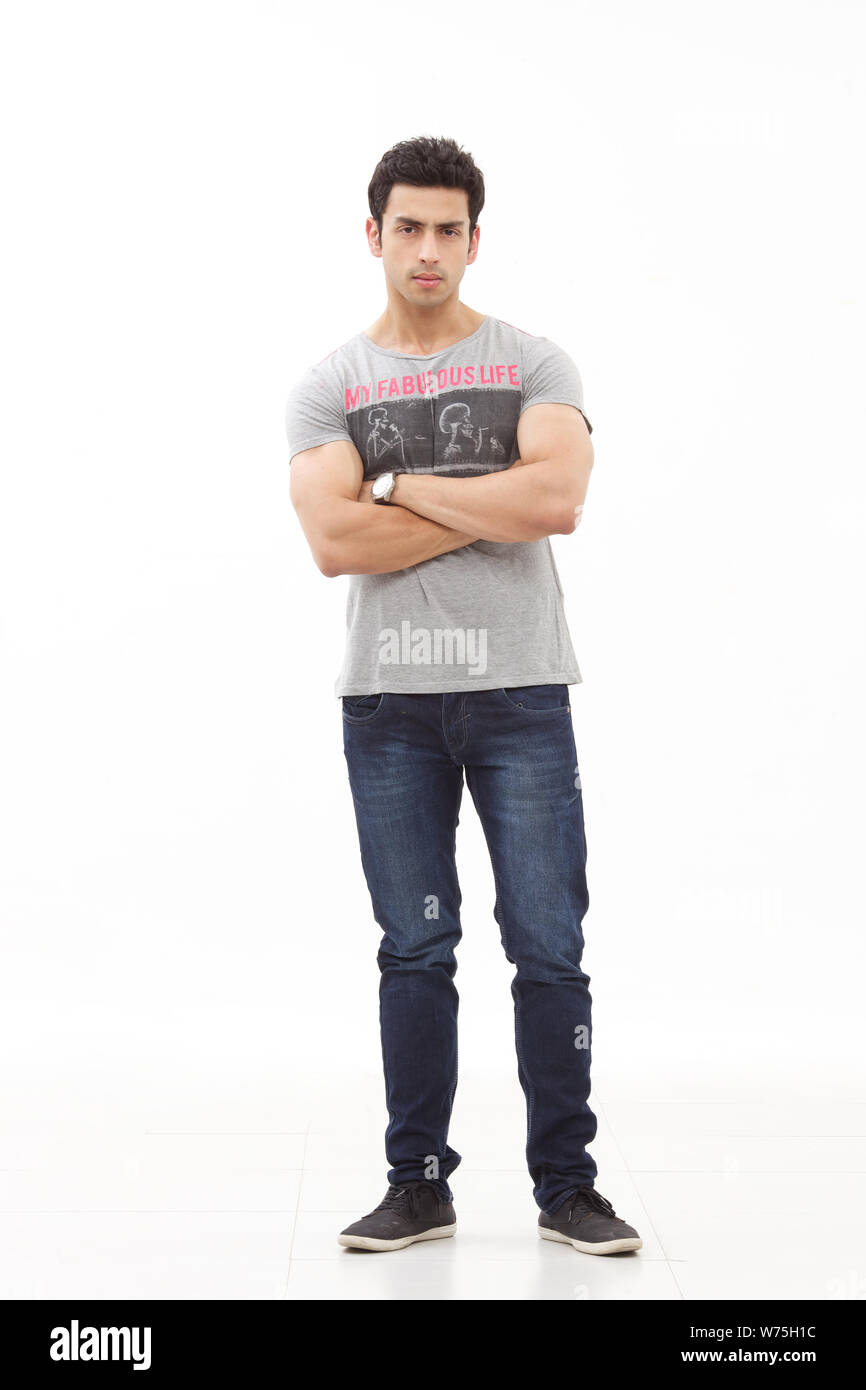 Indian young man standing with his arms crossed Stock Photo - Alamy