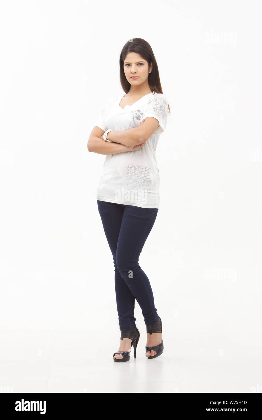 Young woman standing with her arms crossed Stock Photo - Alamy