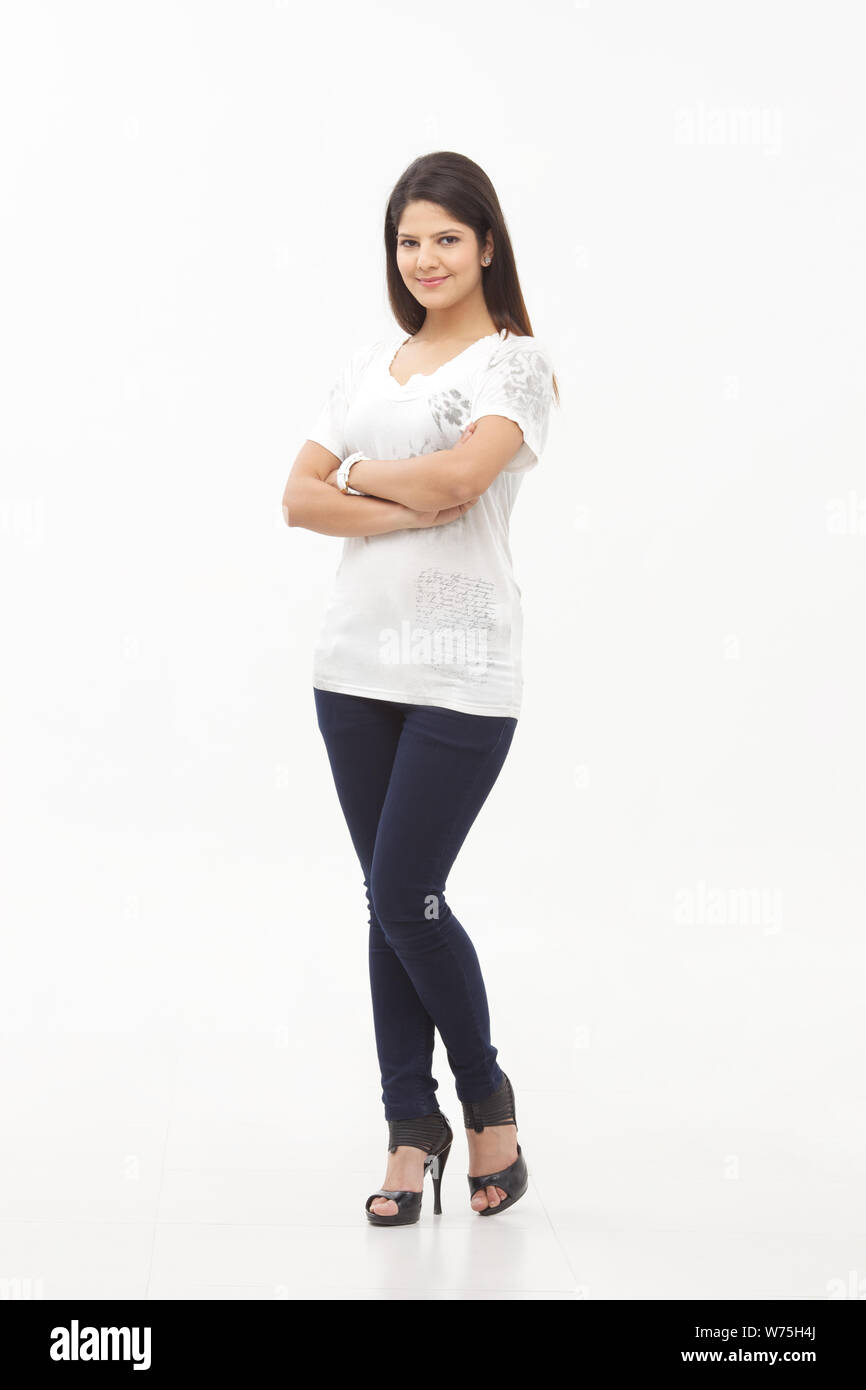 Young woman standing with her arms crossed Stock Photo - Alamy