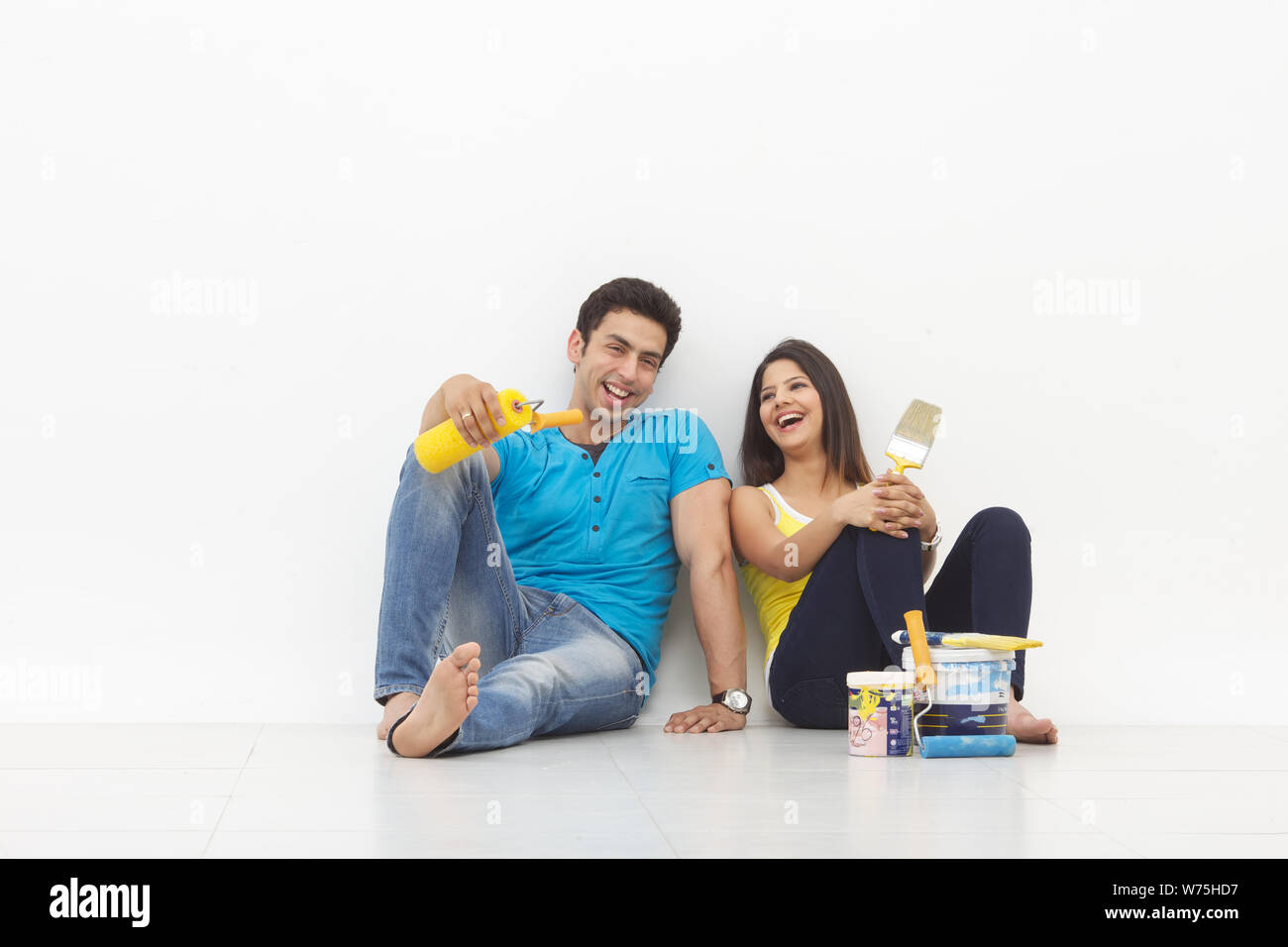 Young couple taking a break while painting their home Stock Photo