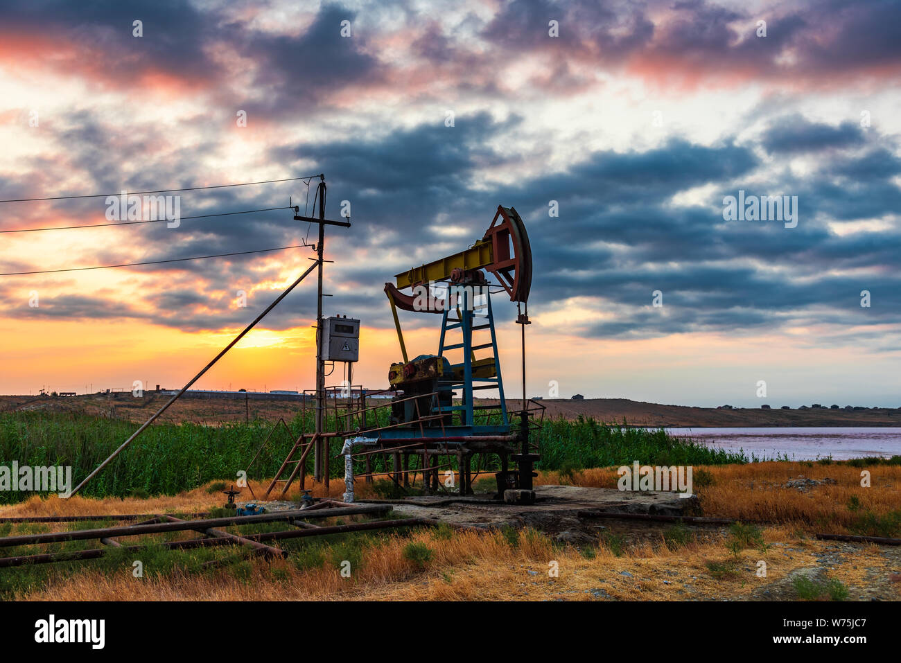 Oil rig pump against a colorful sunset sky Stock Photo - Alamy