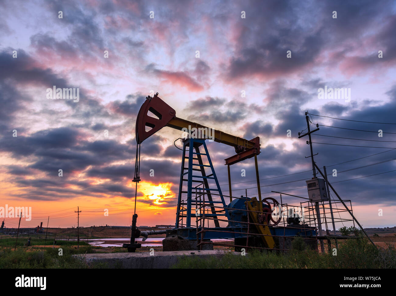 Oil rig pump against a colorful sunset sky Stock Photo - Alamy