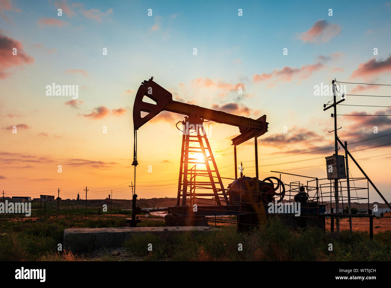 Oil rig pump against a colorful sunset sky Stock Photo - Alamy