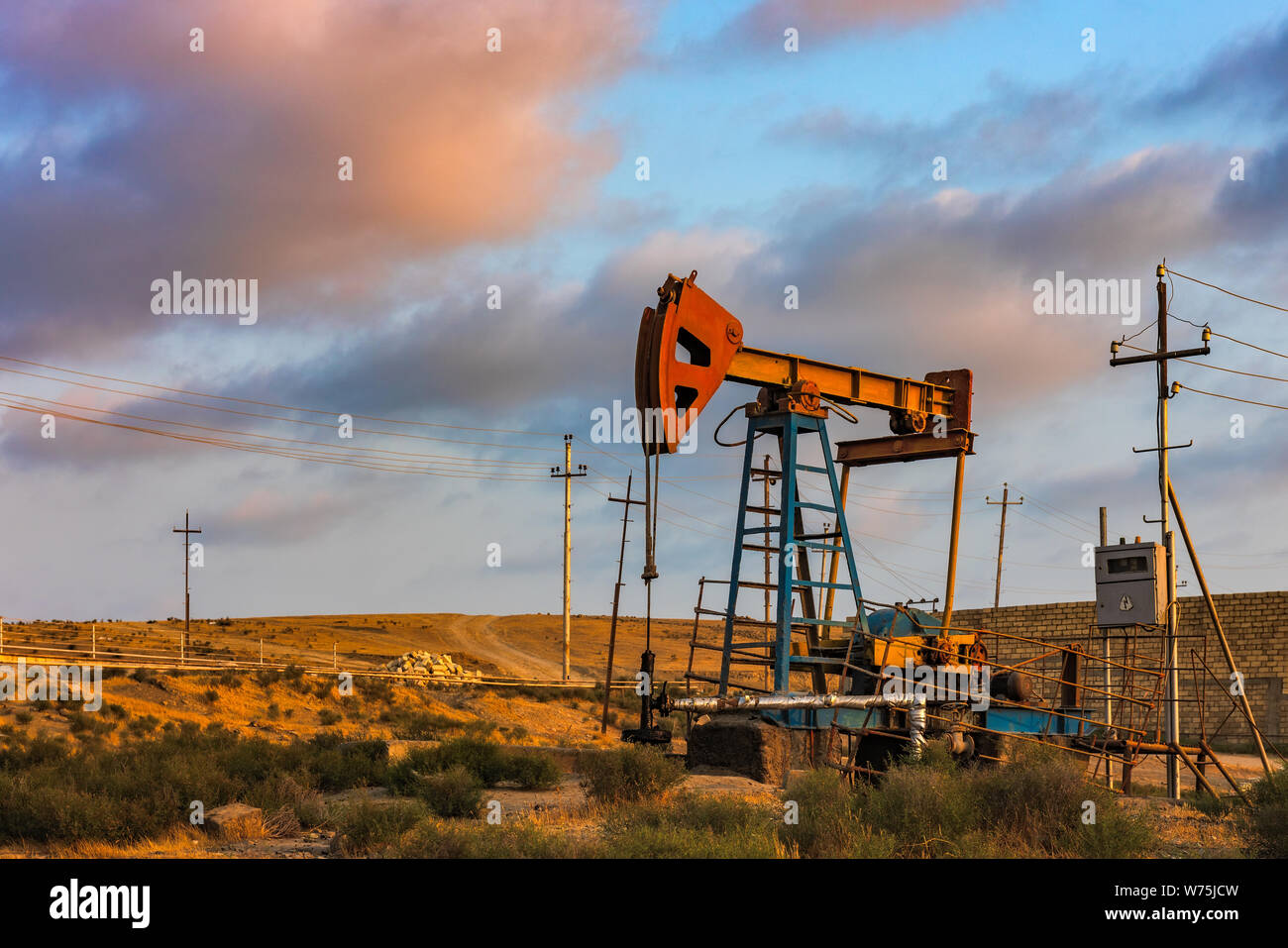 Oil rig pump against a colorful sunset sky Stock Photo - Alamy