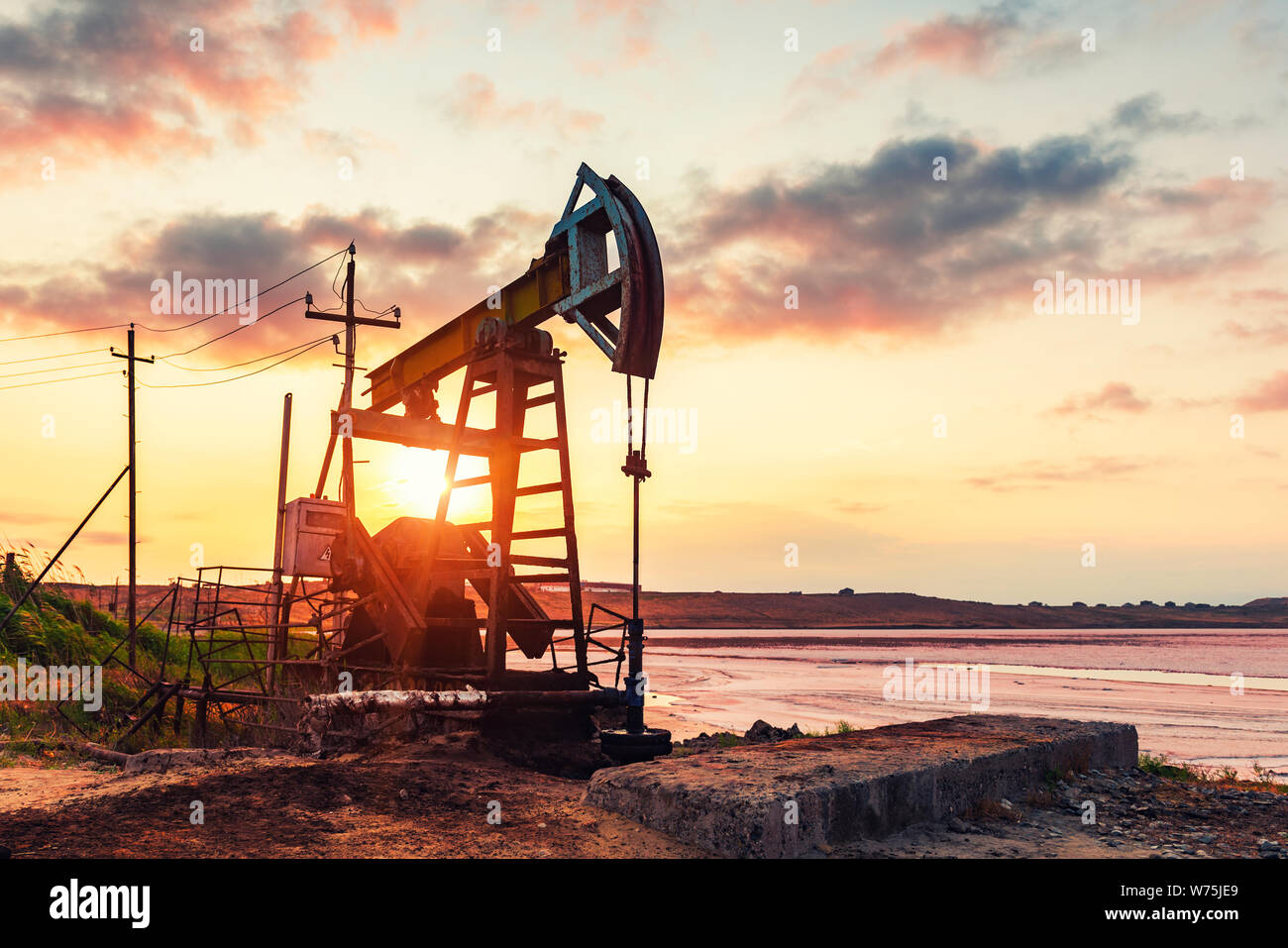 Oil rig pump against a colorful sunset sky Stock Photo - Alamy