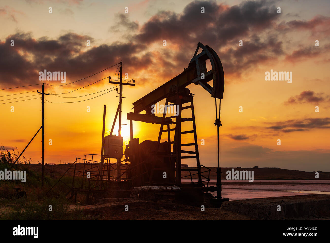 Oil rig pump against a colorful sunset sky Stock Photo - Alamy