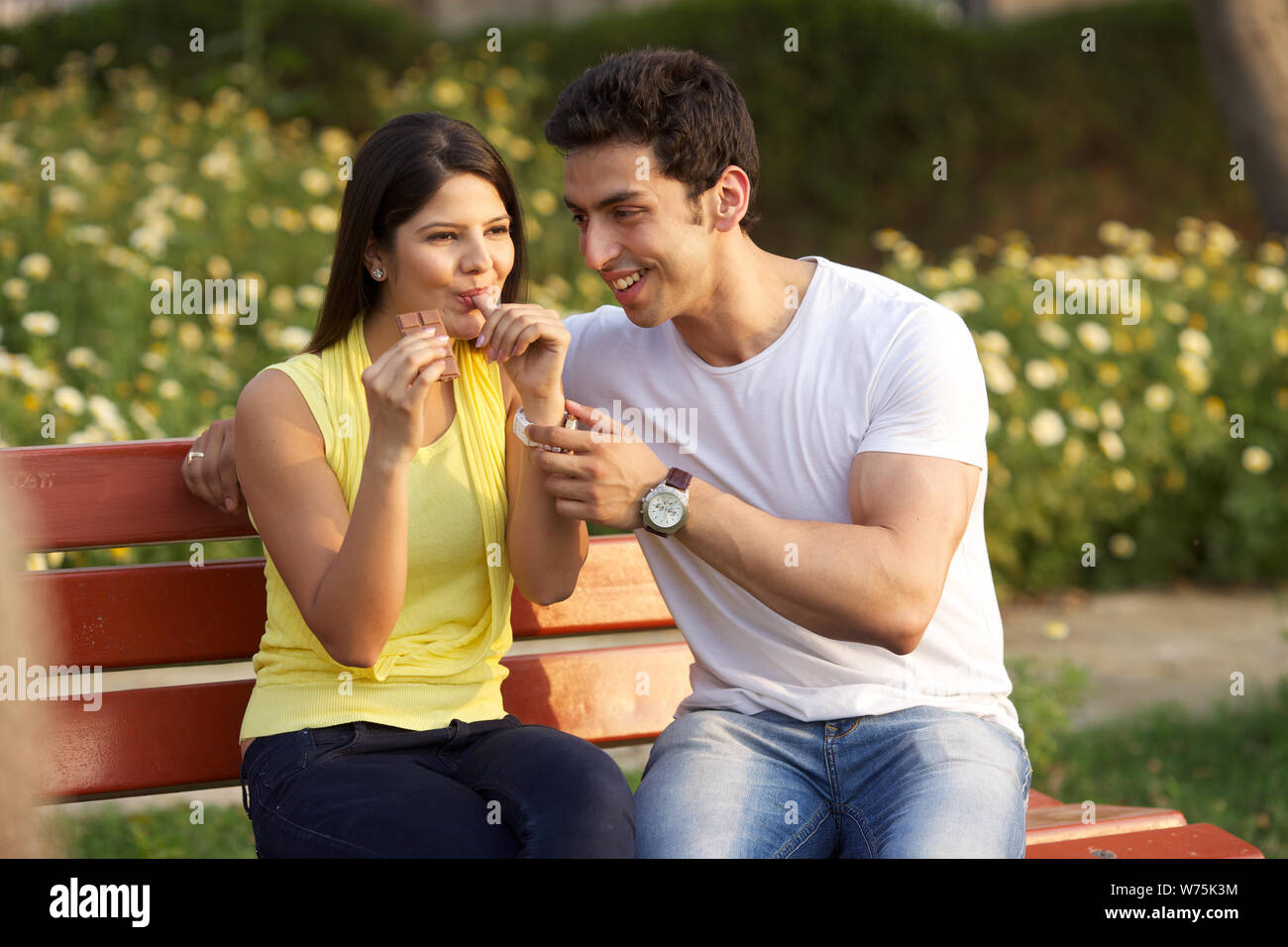 Young woman eating chocolate bar with her husband Stock Photo - Alamy