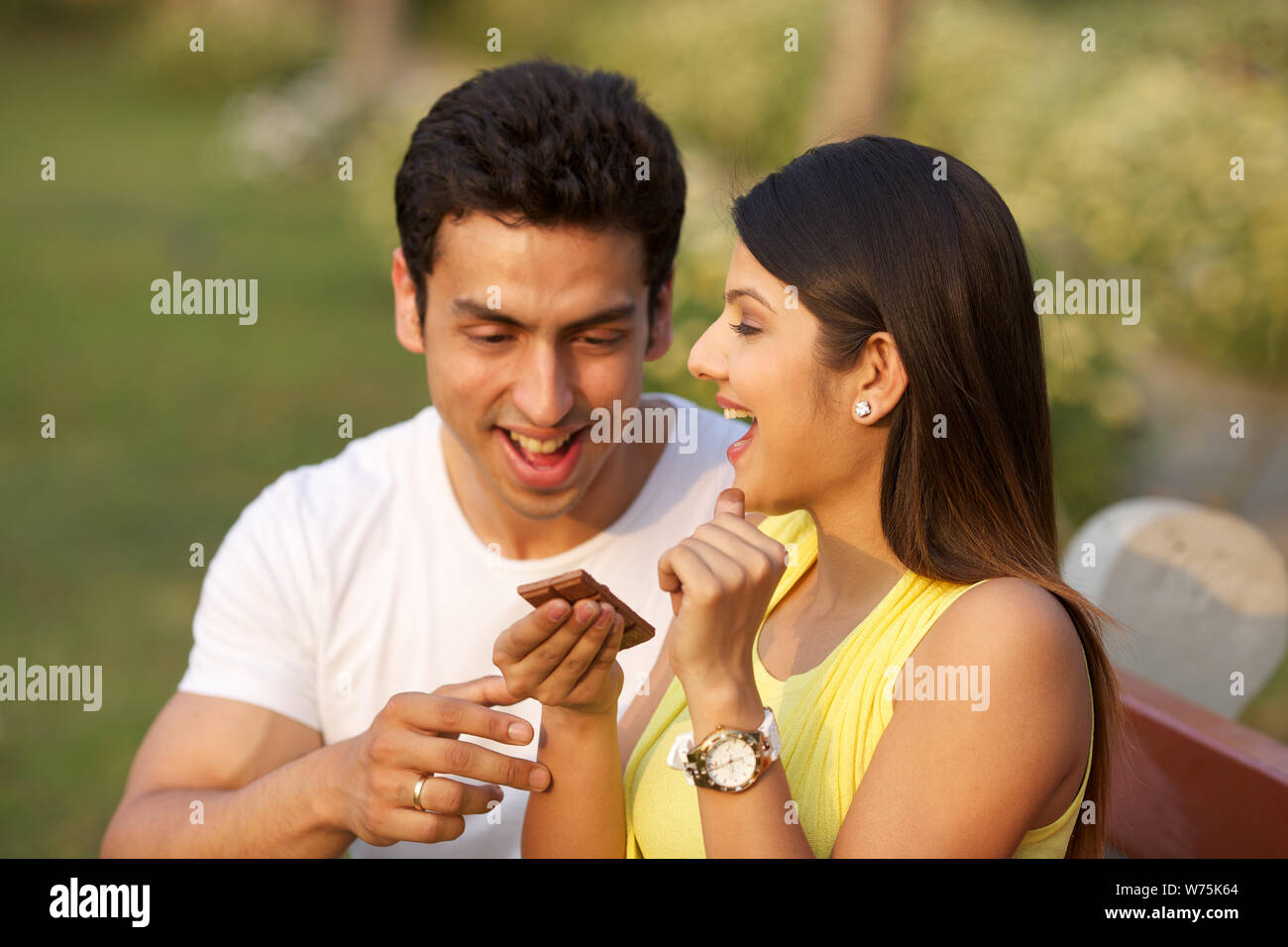 Young couple eating chocolate bar Stock Photo - Alamy