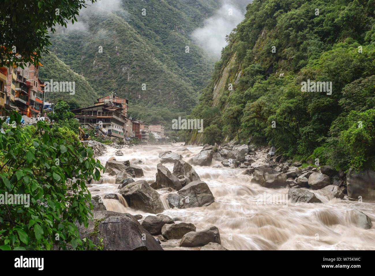 Aguas Calientes town landscape with powerful Urubamaba river on foreground in Peru Stock Photo