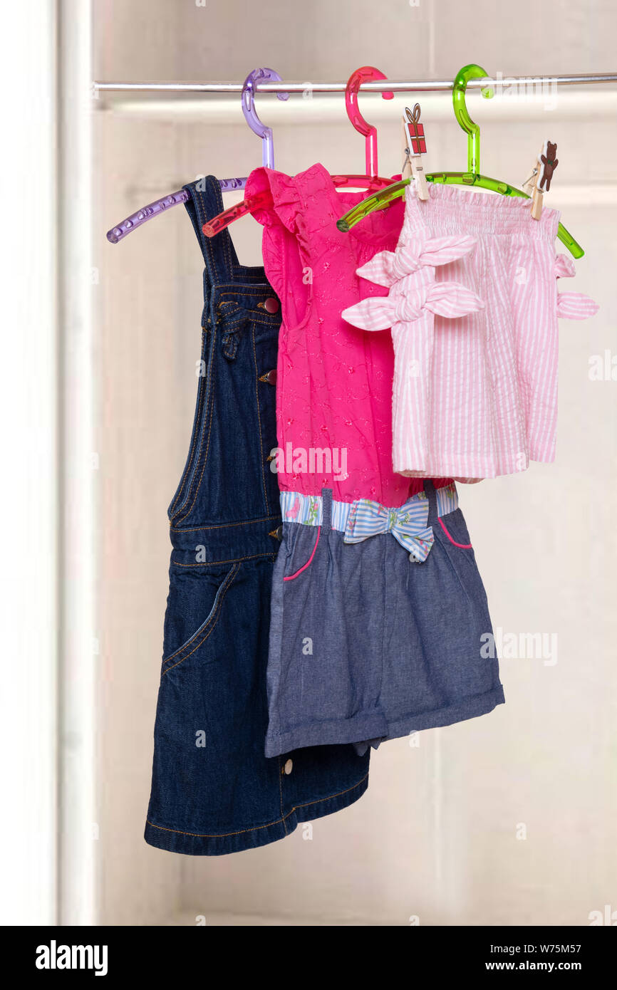 Girls clothes on rack. Collage of colorful stylish summer dresses and a