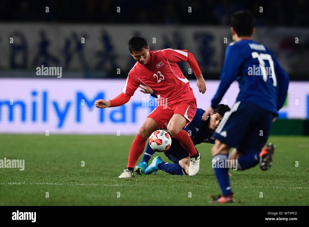 Yasuyuki Konno of Japan, right, and one of his teammates challenge Kim Yu Song of North Korean during the EAFF E-1 Football Championship Final match a Stock Photo