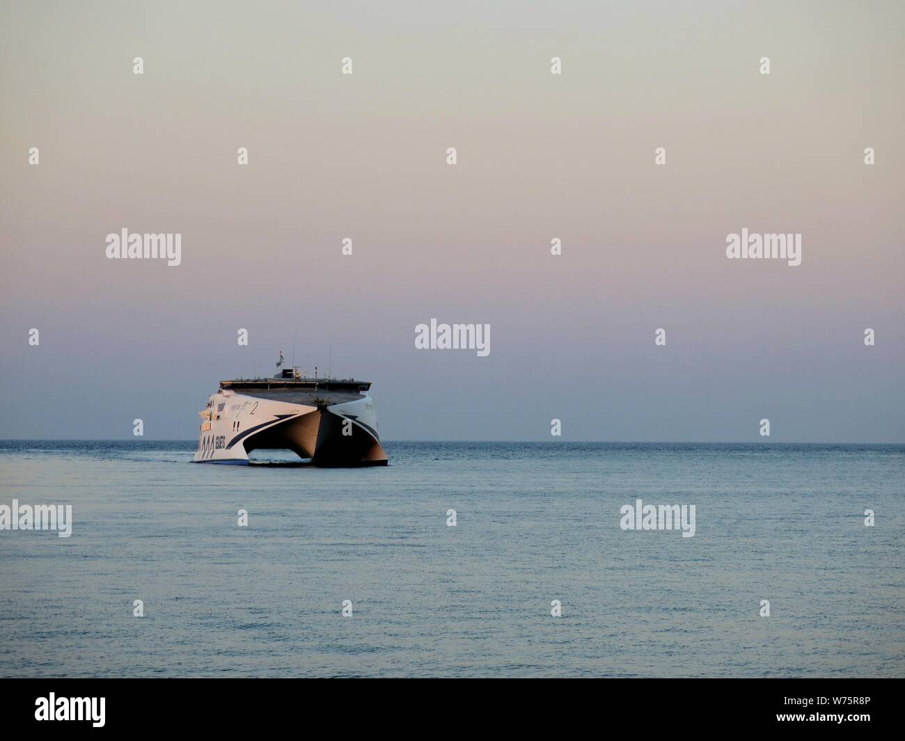 High Speed ferry approaching Heraklion harbour during sunset. Stock Photo