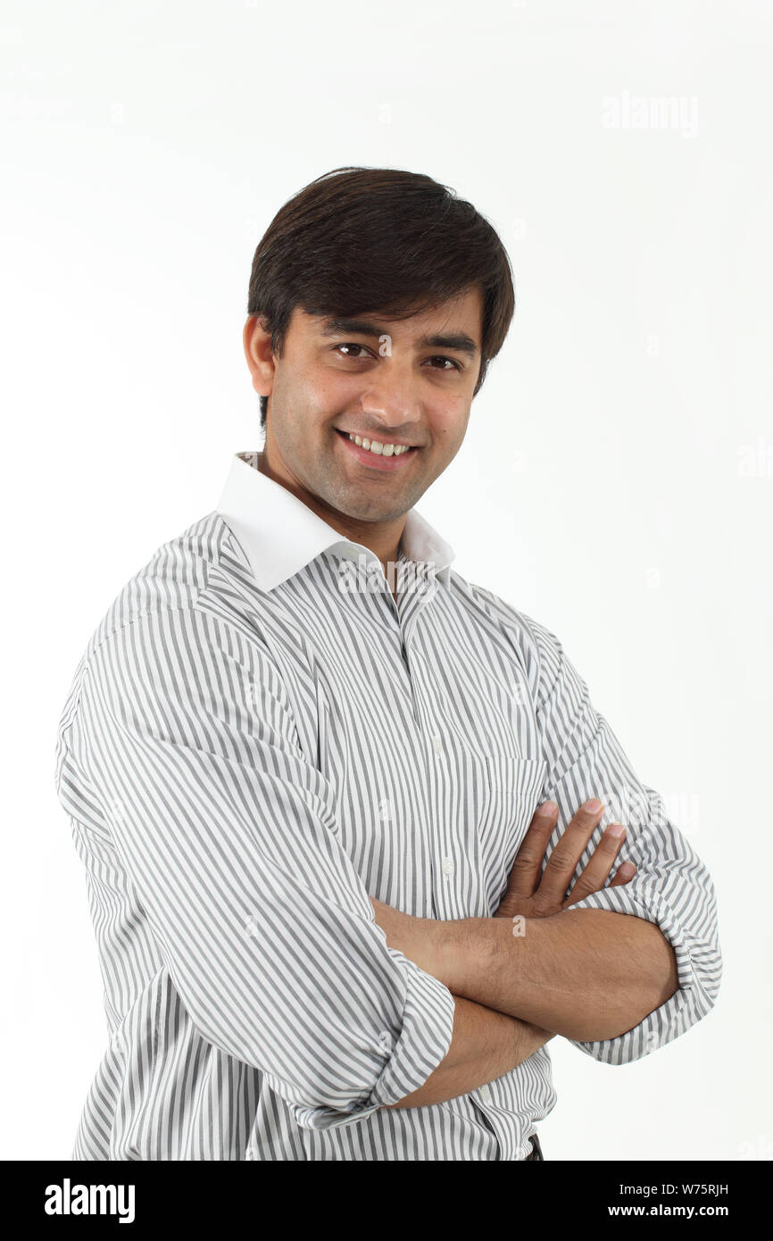 Indian young man smiling with his arms crossed Stock Photo Alamy
