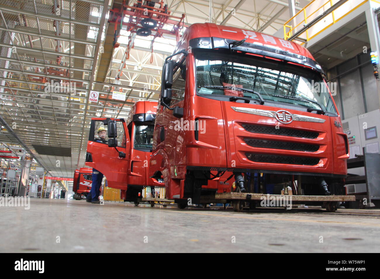 --FILE--A Chinese worker assembles trucks on the assembly line at an ...