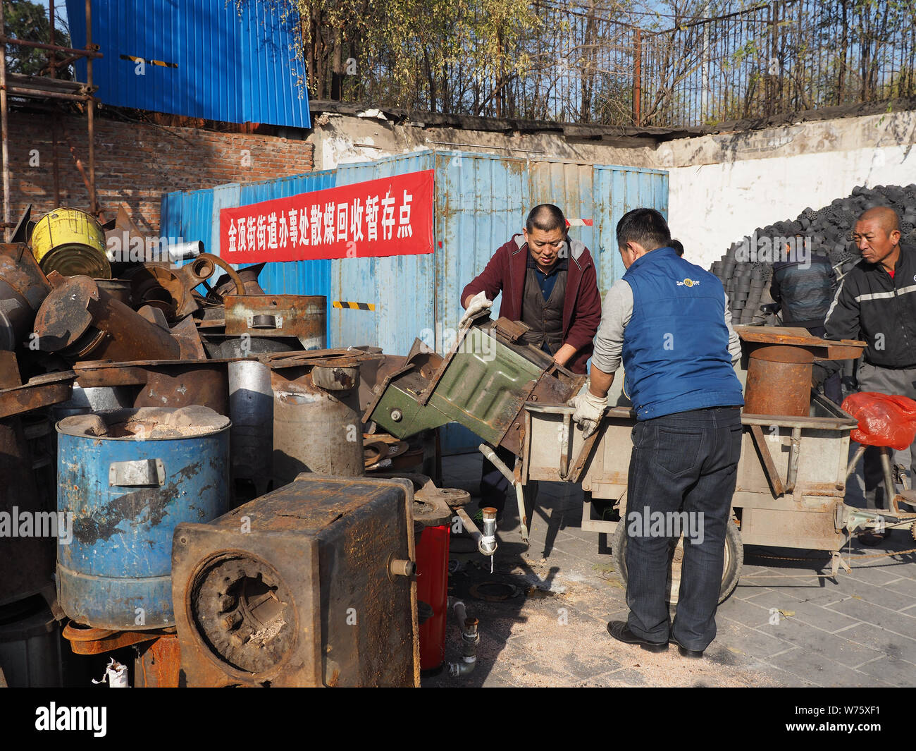--FILE--A Chinese worker helps local residents to collect coal stoves for recycling during a campaign to switch coal-fired heating to clean energy at Stock Photo