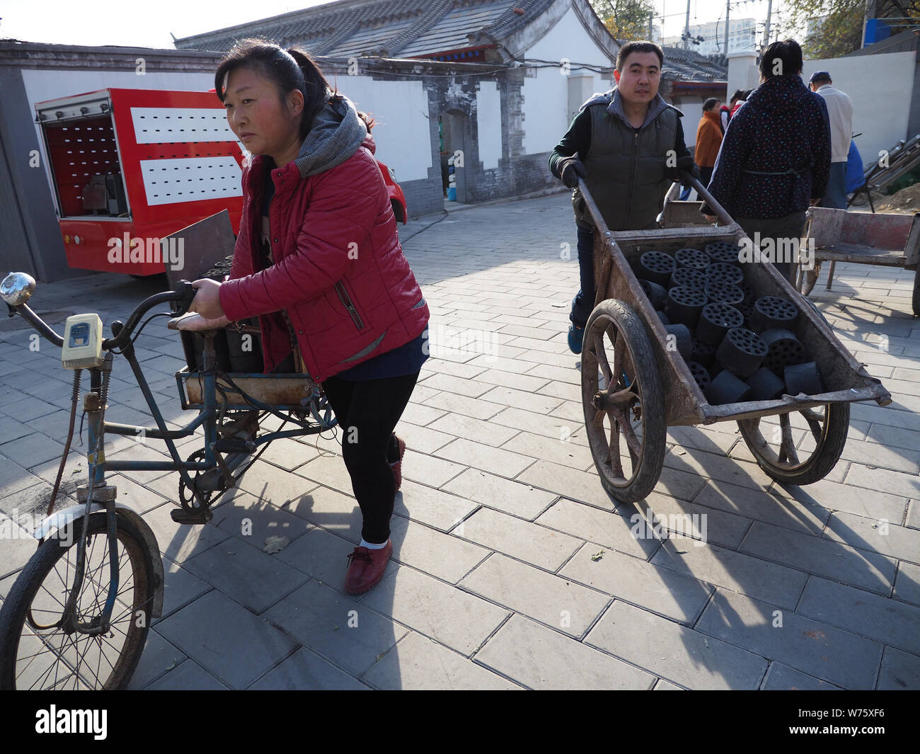 --FILE--Local residents transport coal cakes for recycling during a campaign to switch coal-fired heating to clean energy at a village in Shijingshan Stock Photo