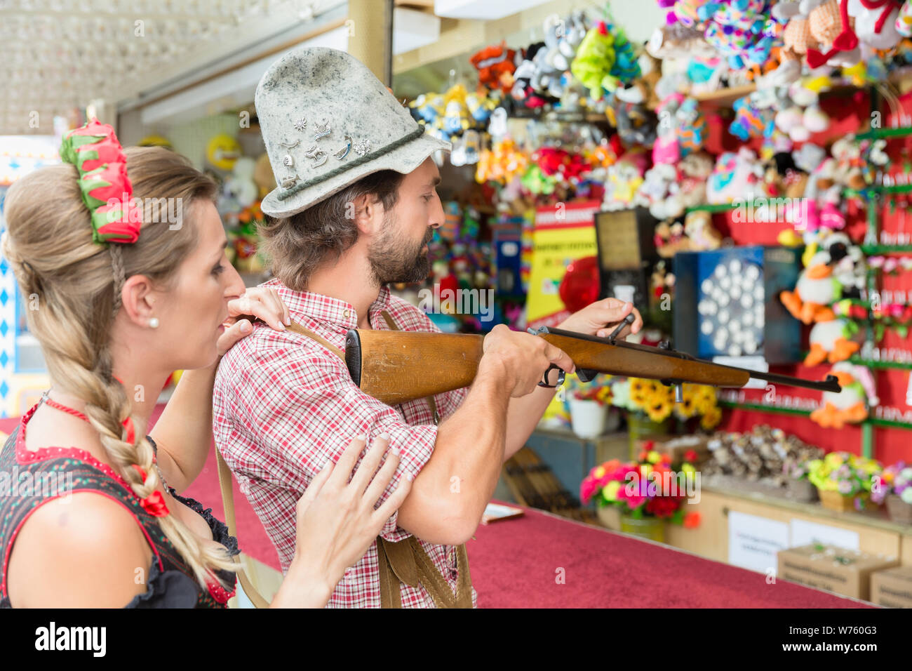 Couple on Bavarian fair at the shooting gallery Stock Photo