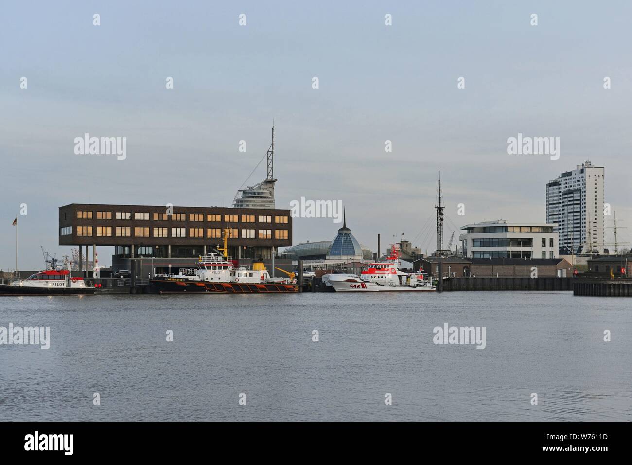 Bremerhaven's pilot station at the river Geeste's mouth with pilot boats and the recue cruiser Hermann Rudolf Meyer and the high-rise buildings from the city centre in the distance, 7 April 2018 | usage worldwide Stock Photo