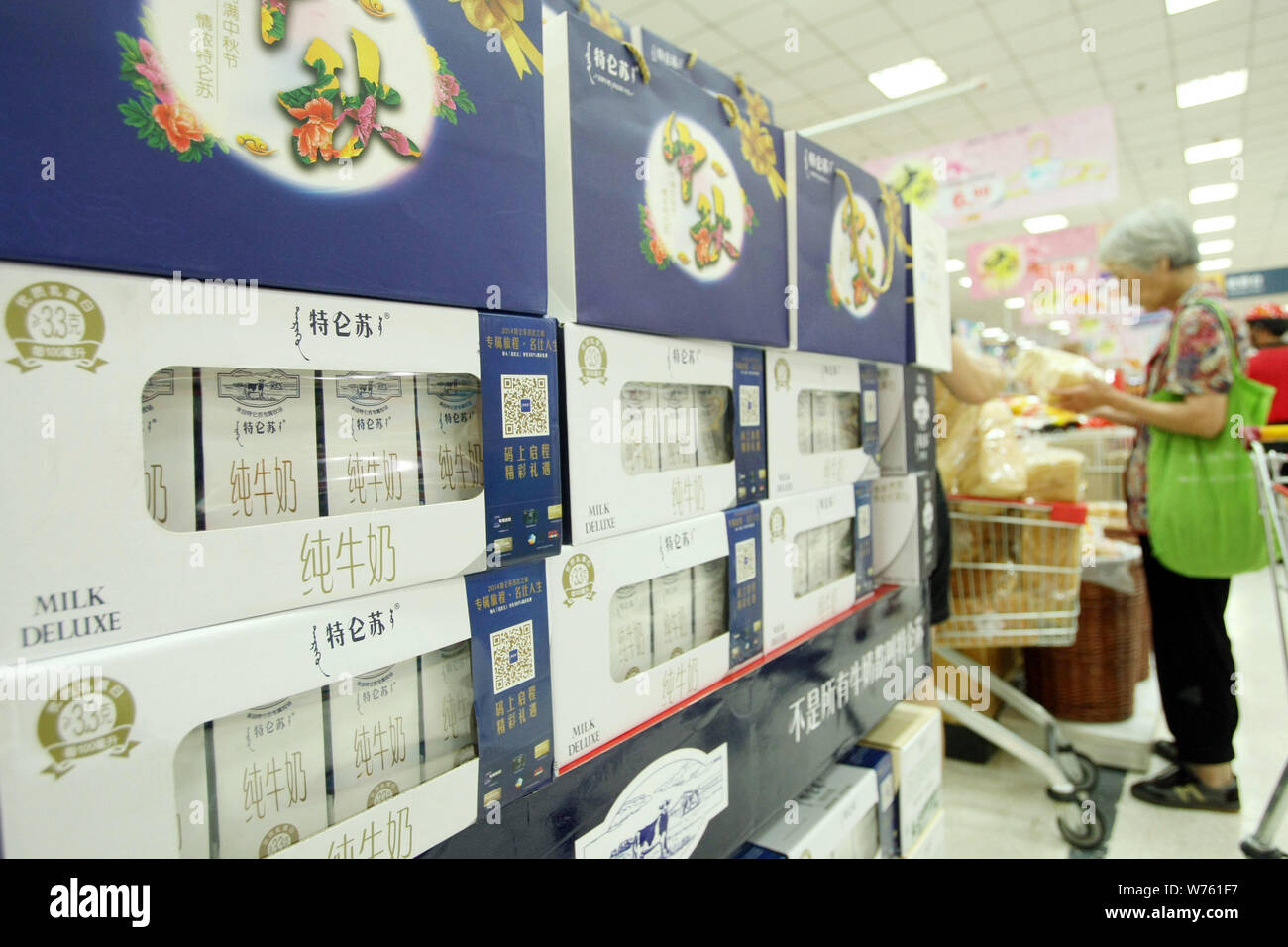 FILEA Chinese customer walks past cartons of Mengniu Milk Deluxe at