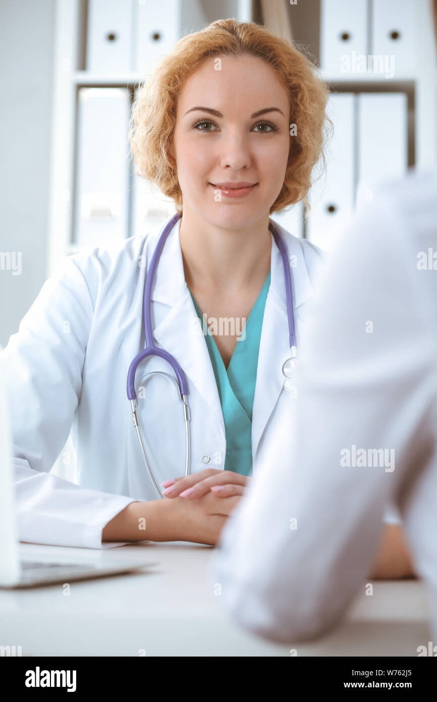 Happy Blonde Female Doctor And Patient Discussing Medical Examination