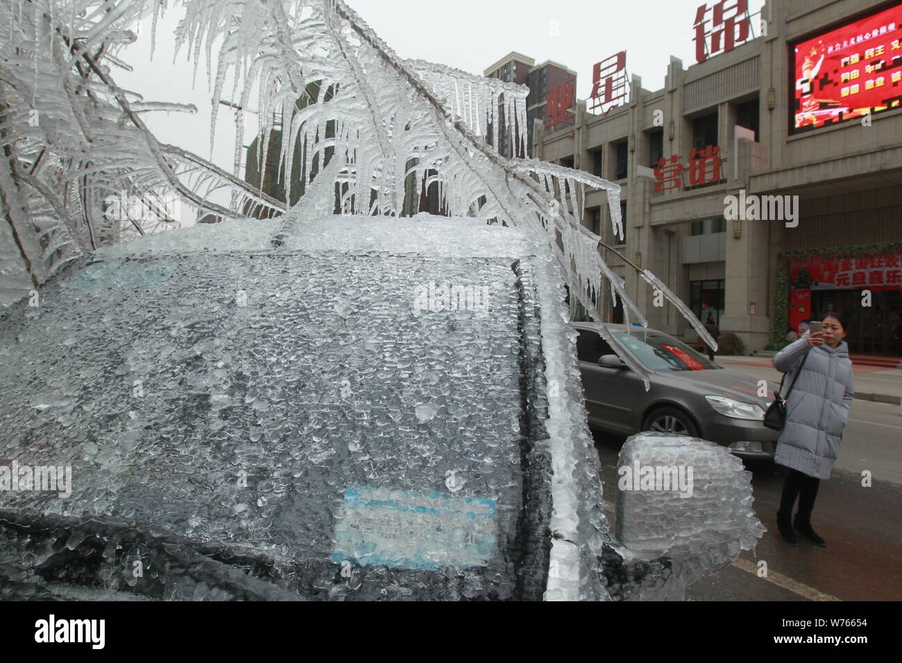 A car is frozen and immovable due to a sudden drop of the temperature on a street in Zhengzhou city, central China's Henan province, 12 December 2017. Stock Photo