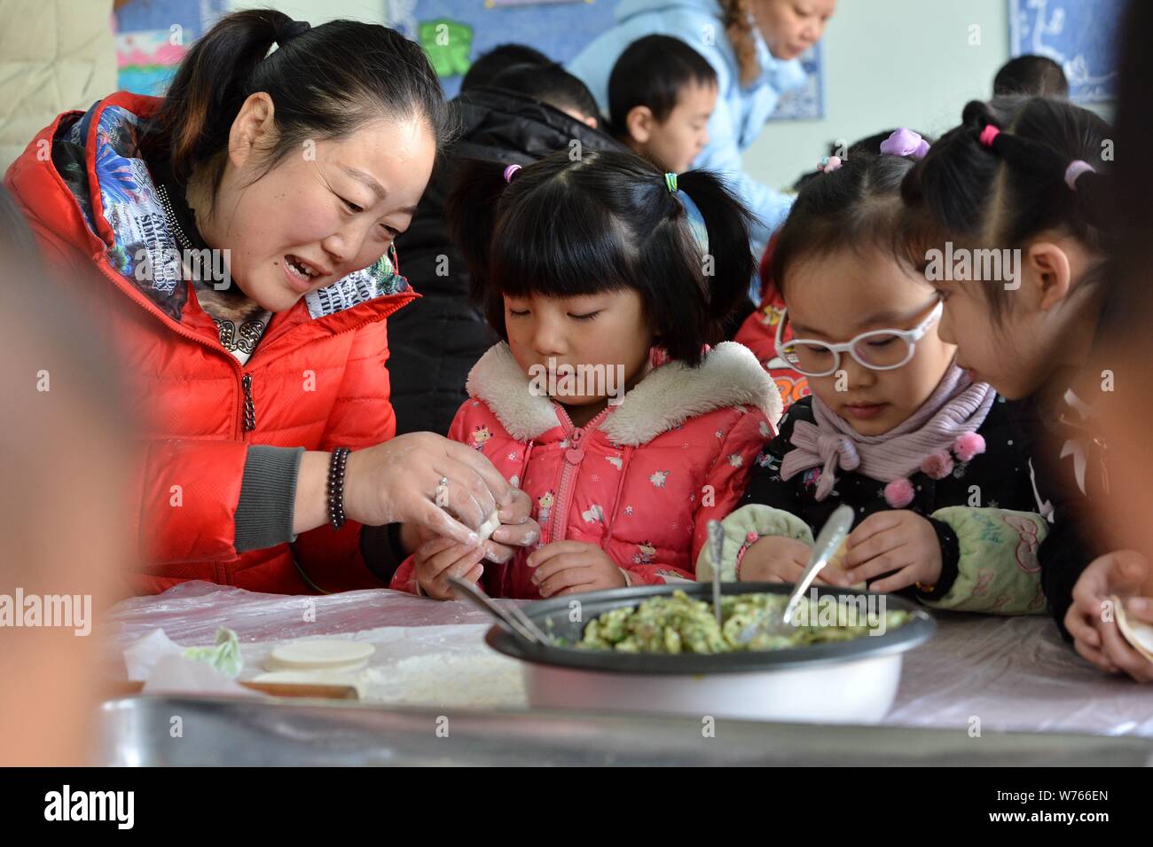 Chinese children make dumplings with their teacher to celebrate the ...