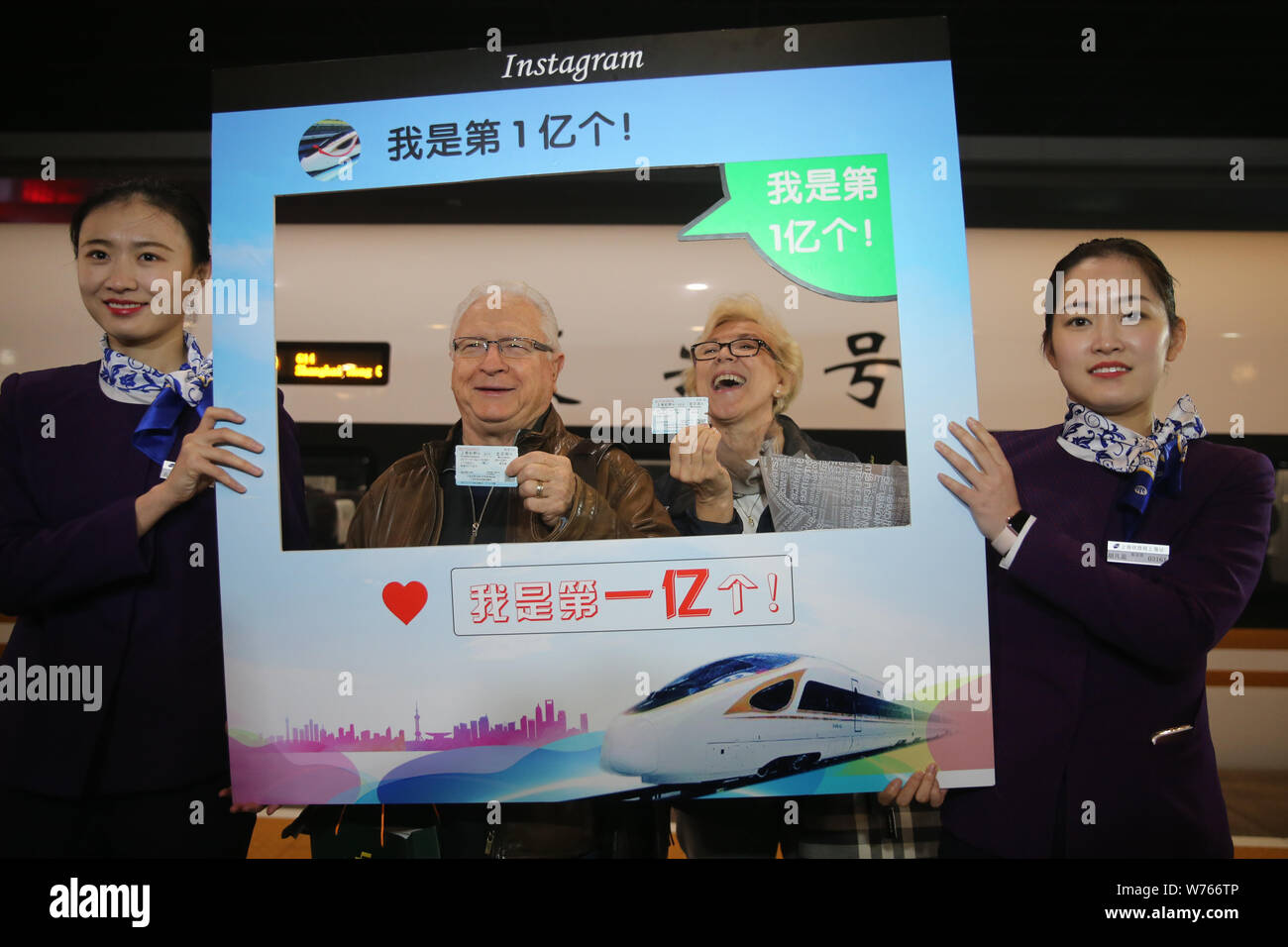79-year-old American businessman Charles Bingham, who is the city's 100 millionth outbound train passenger this year, poses for photos with his wife a Stock Photo